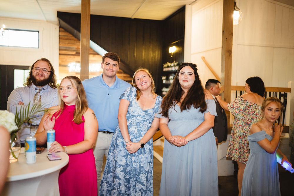 People gather in a casual indoor space celebrating and raising drinks together during a social event.
