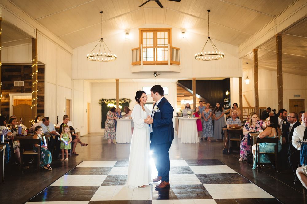 A romantic first dance between newlyweds in an elegant ballroom as guests watch during a wedding reception.