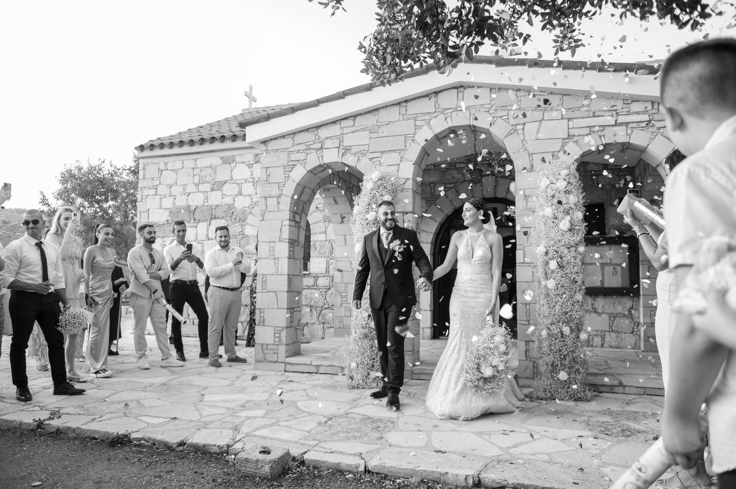 A panoramic series shows people walking across the curved stone tiers of an ancient amphitheater under bright sunlight.