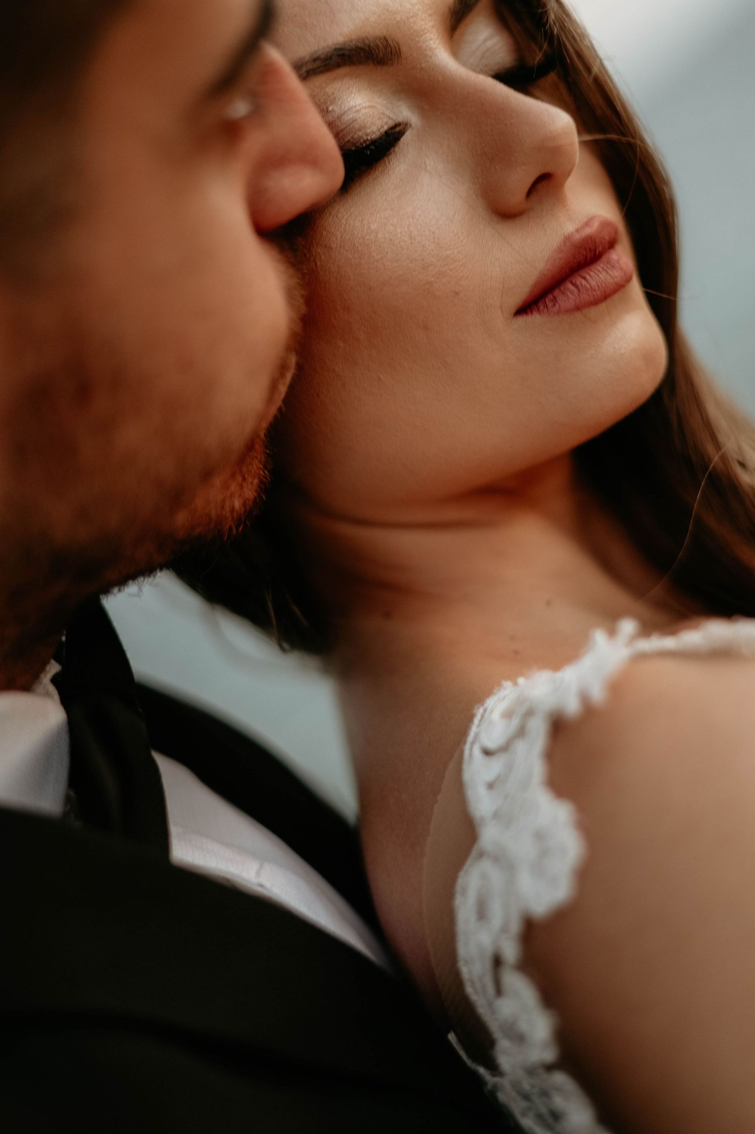 Close up shots of tender wedding moments showing romantic poses with delicate lace dress details visible.