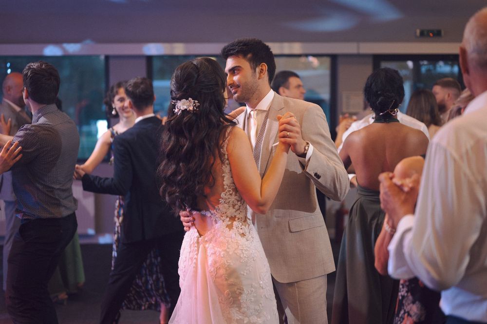 Wedding guests dancing and celebrating on a dimly lit dance floor during a reception party.