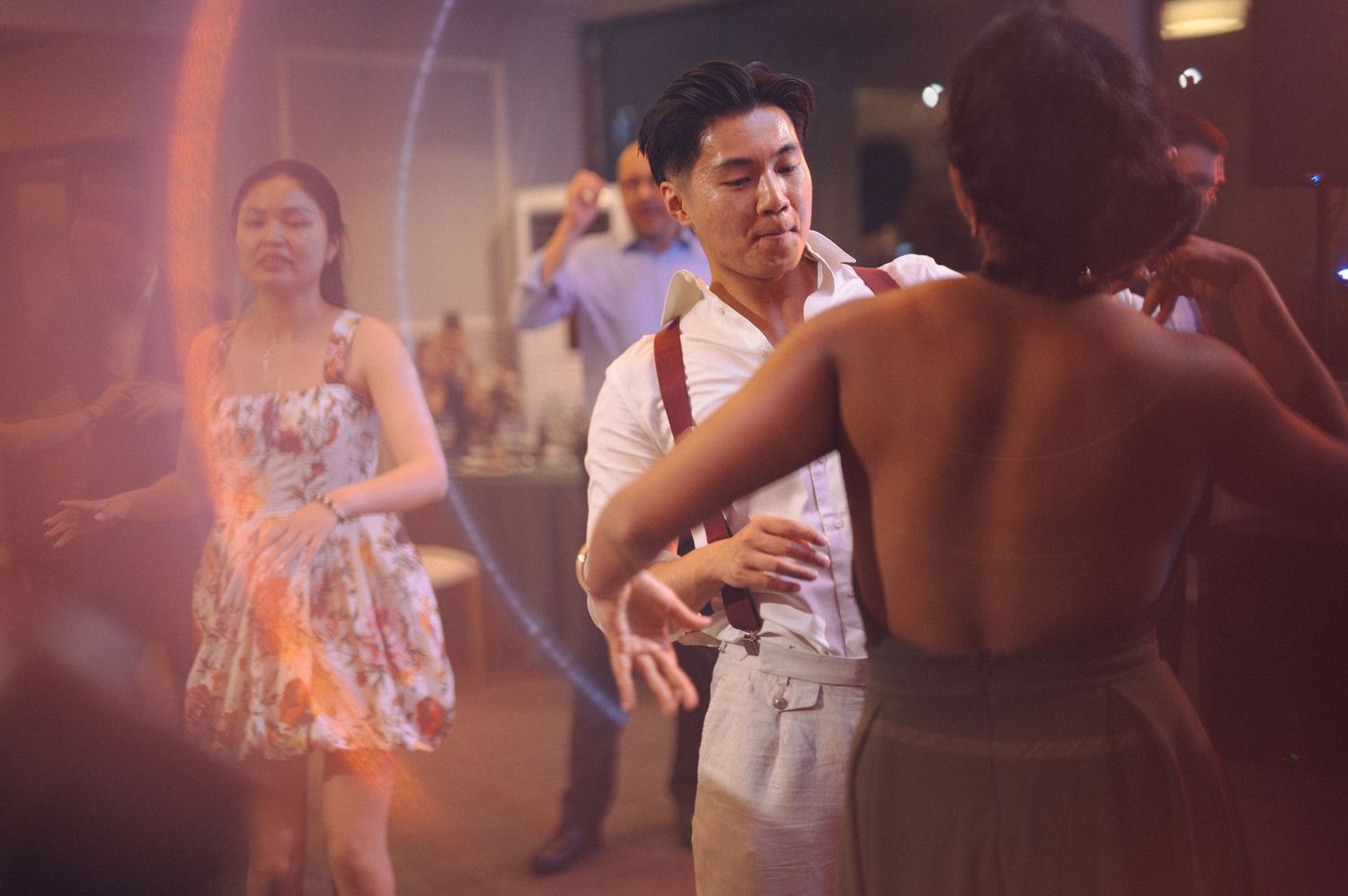 People dancing together at an evening reception or party with soft lighting creating a romantic atmosphere.