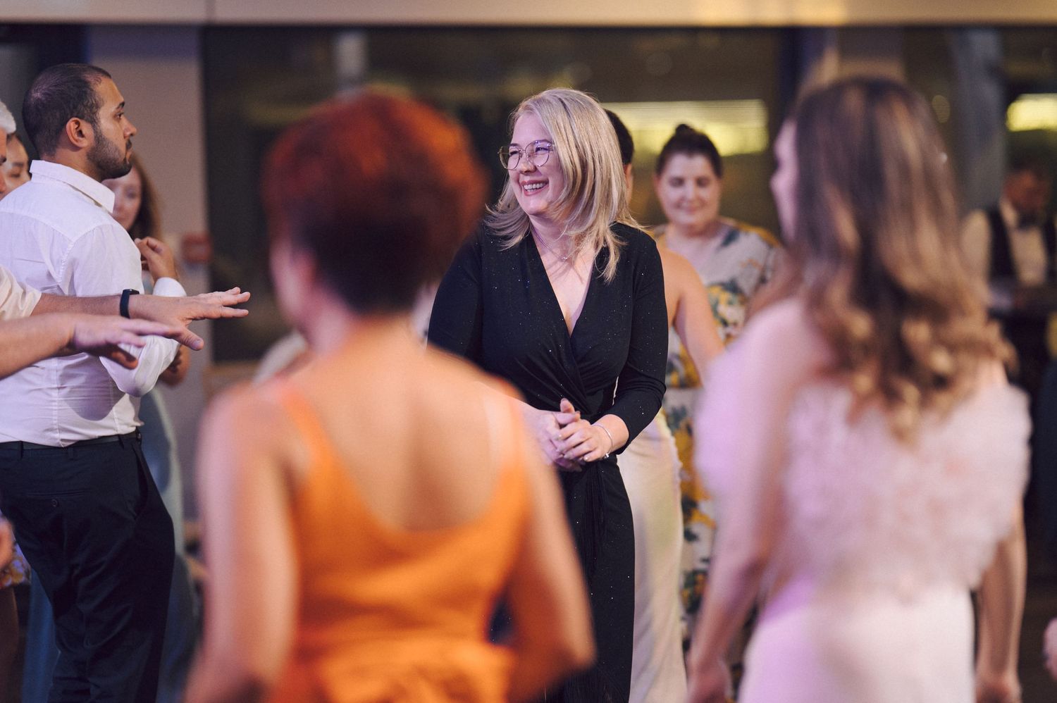 People enjoying themselves on a lively dance floor at an evening event.