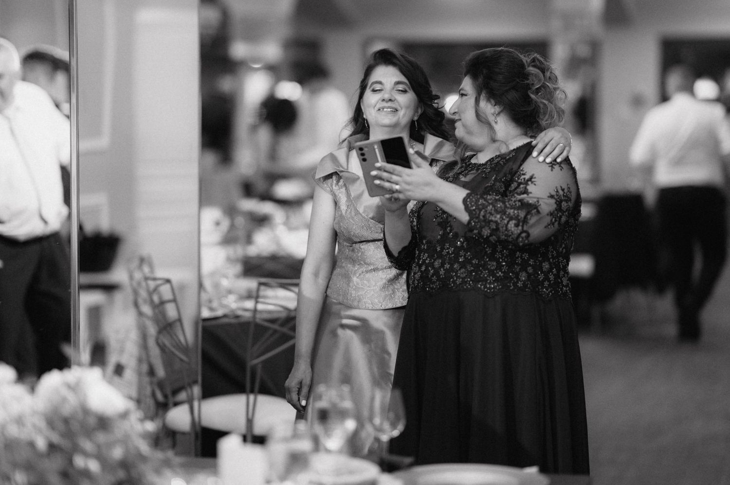 Black and white photo of guests mingling and dancing at an elegant reception.
