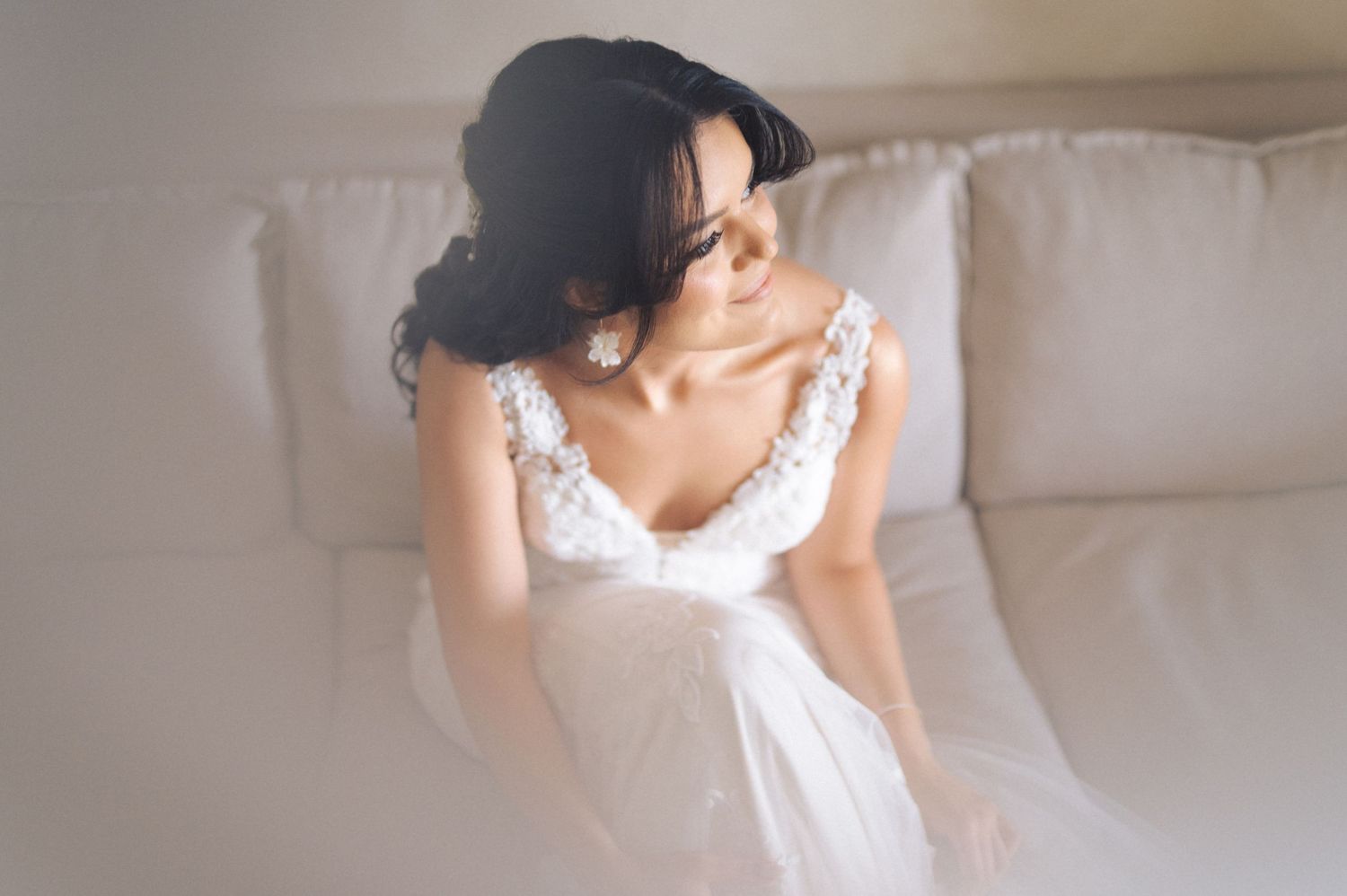 A bride in a white dress holds her bouquet while getting ready for her wedding ceremony.