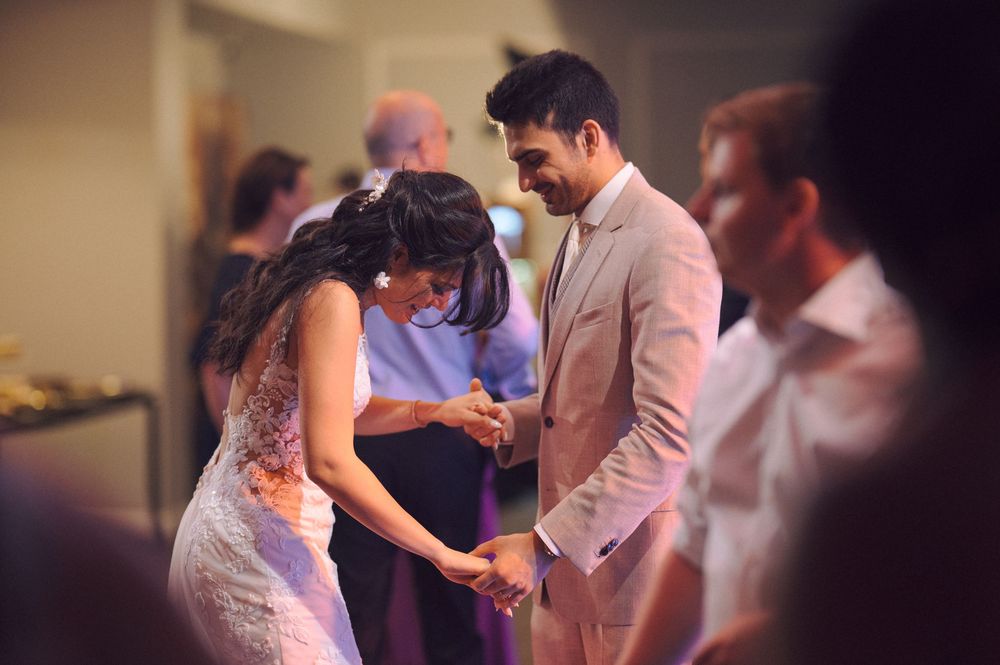 Couple dancing intimately during a wedding reception in soft lighting.