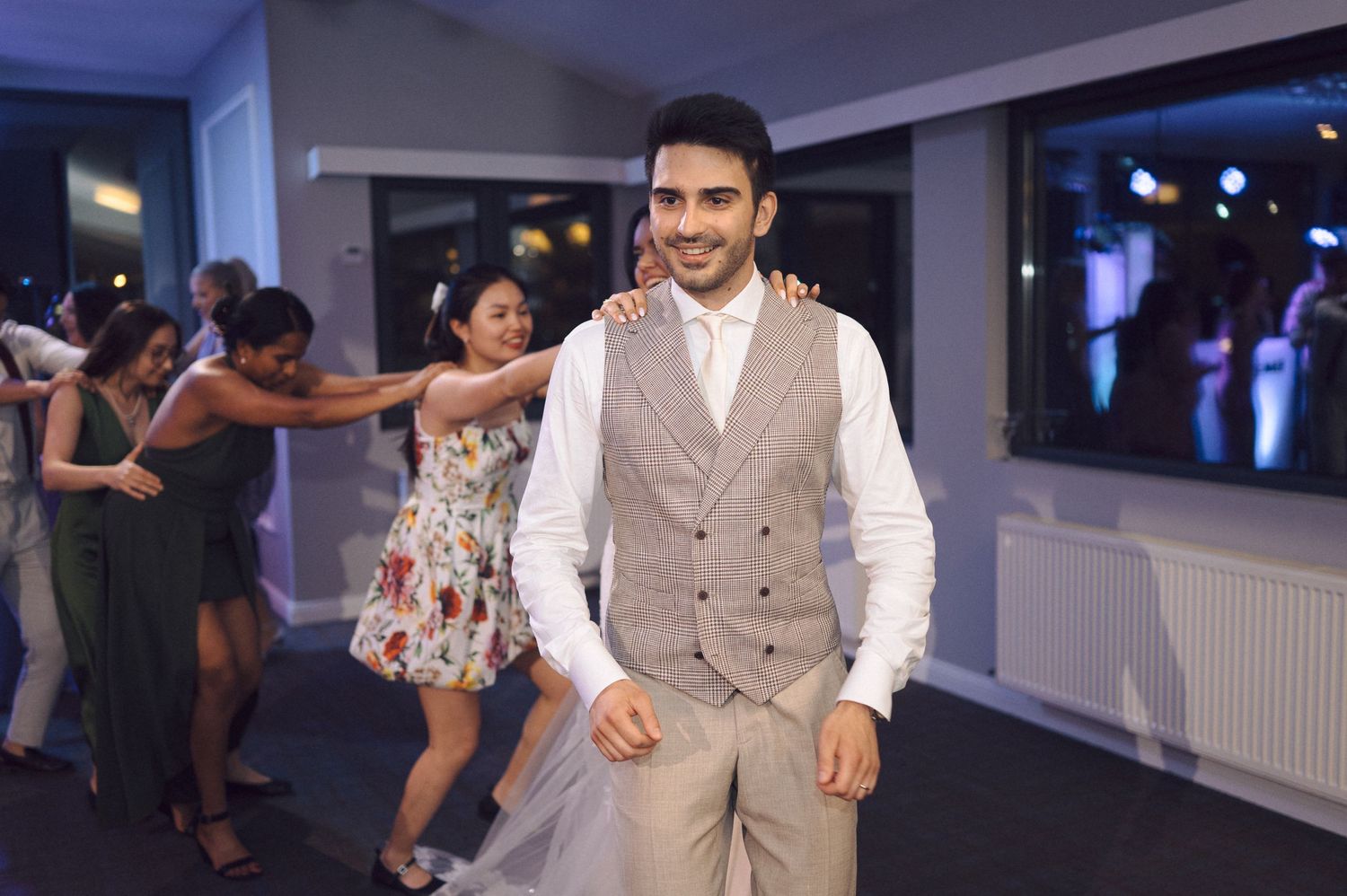 Couples dancing together at an indoor social dance event in a brightly lit venue with modern decor.
