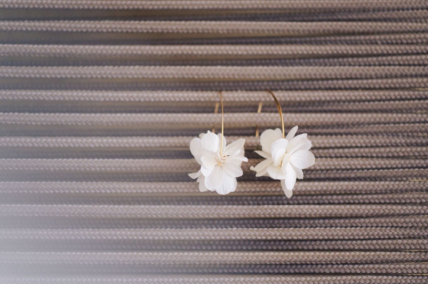 Delicate white floral hair accessories arranged on a textured gray background.