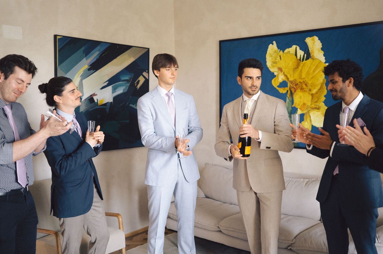 Group of formally dressed people laughing and socializing at an indoor gathering.