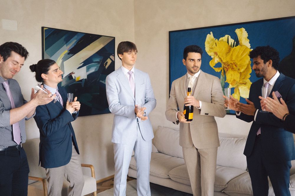 Group of formally dressed people laughing and socializing at an indoor gathering.