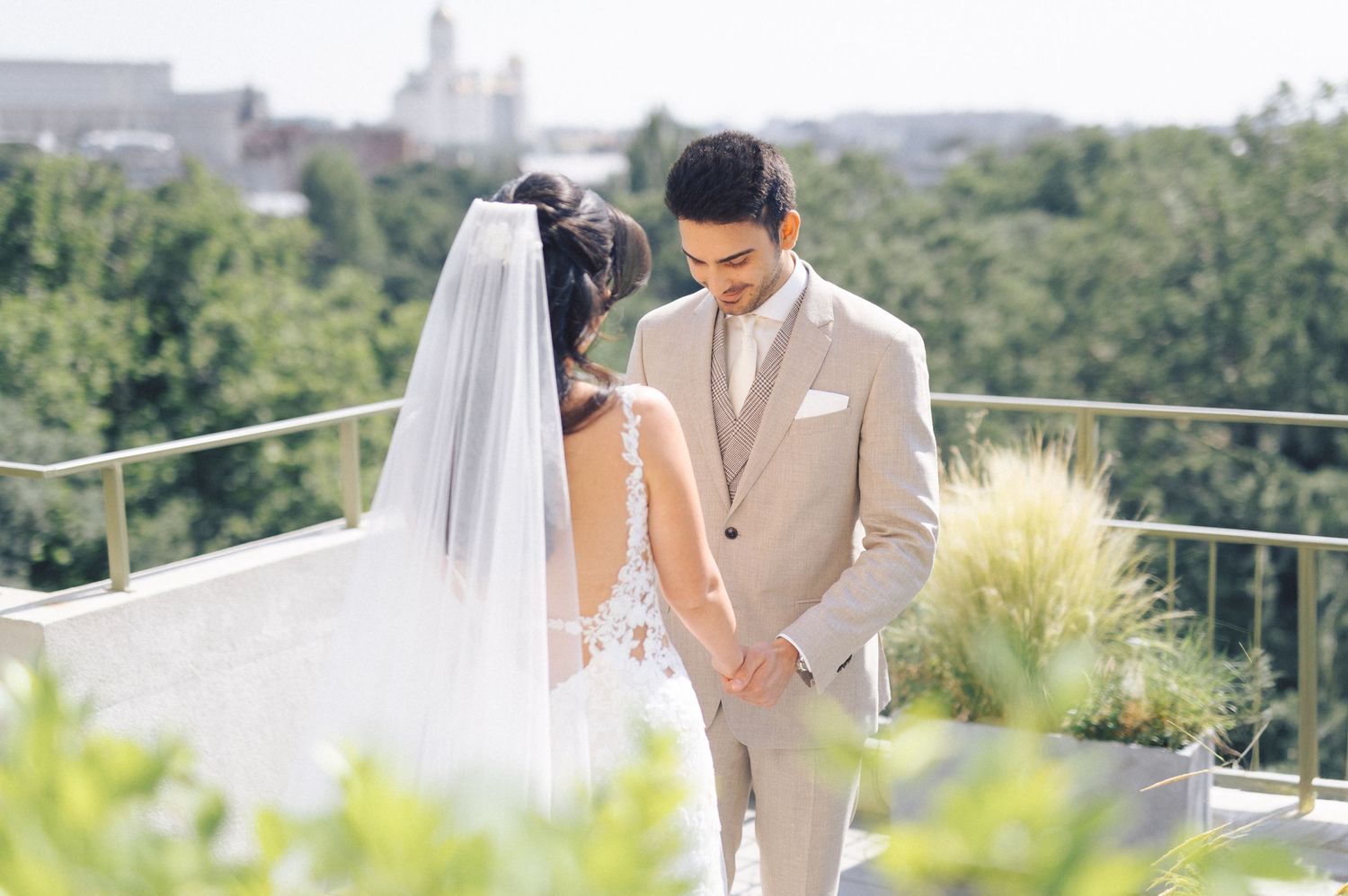 Couple sharing tender romantic moments during a scenic outdoor wedding photo session on a sunny day.
