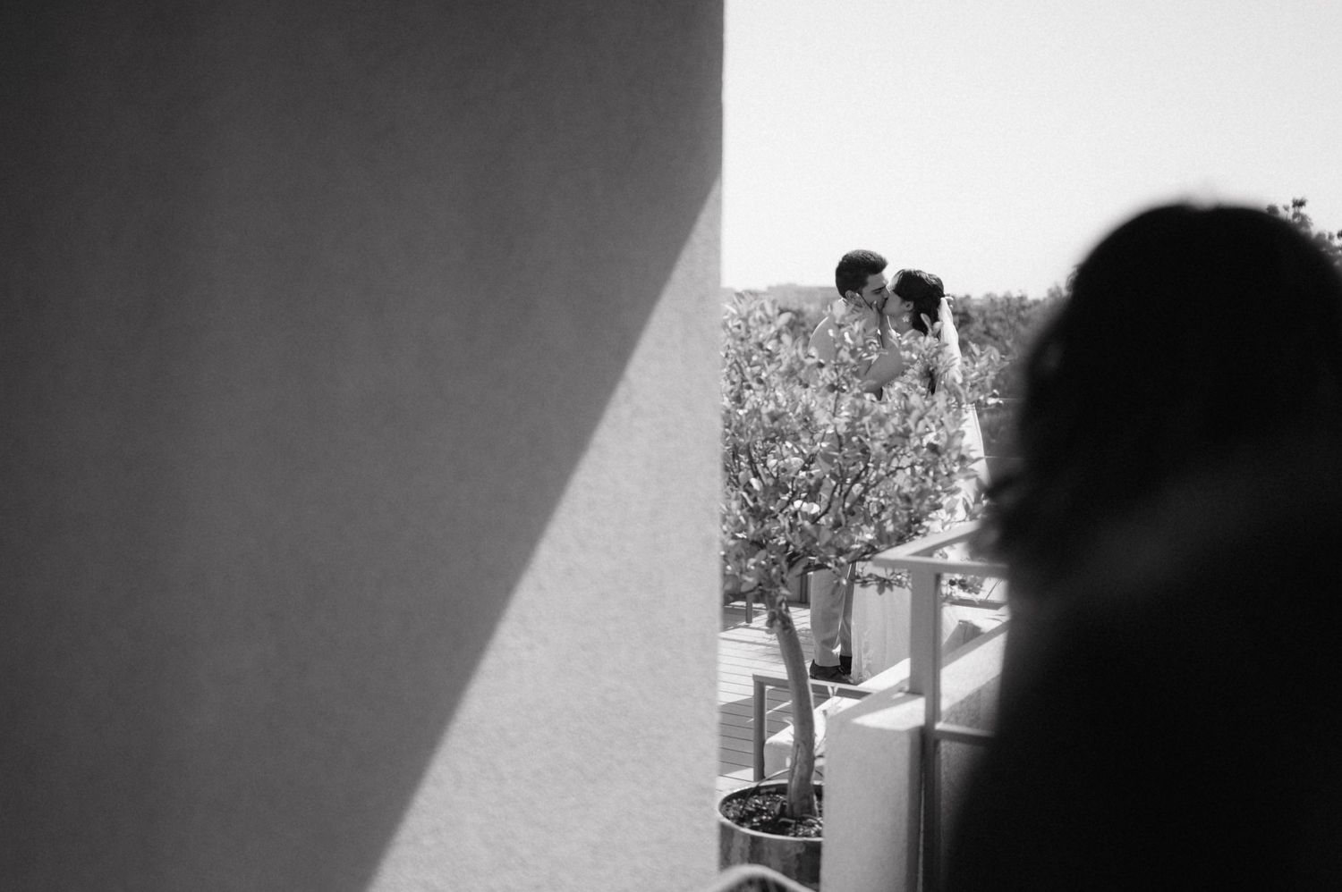 A black and white photograph showing silhouettes of people in what appears to be a tunnel or corridor.