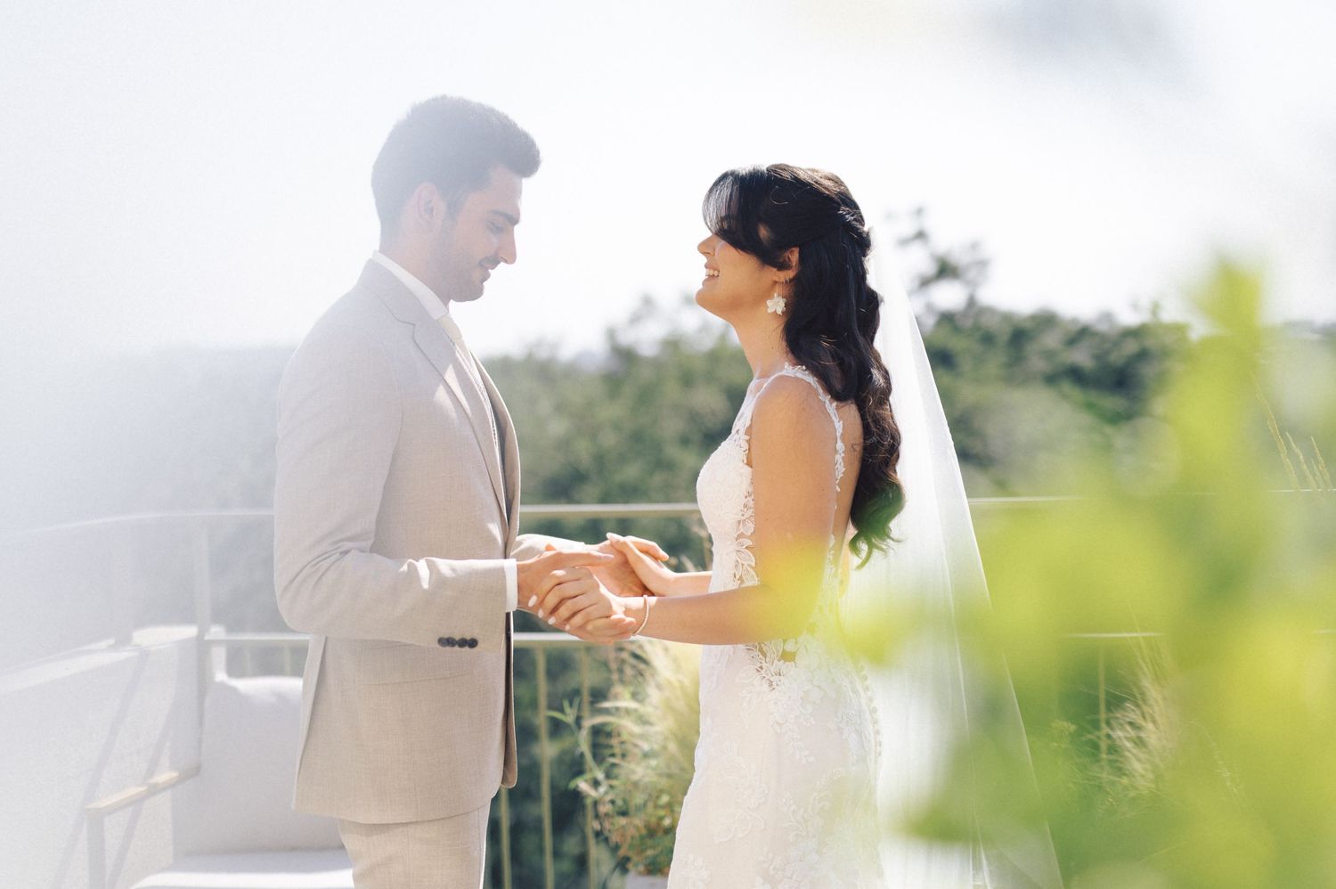 A bride and groom share a tender moment together during their outdoor summer wedding ceremony.