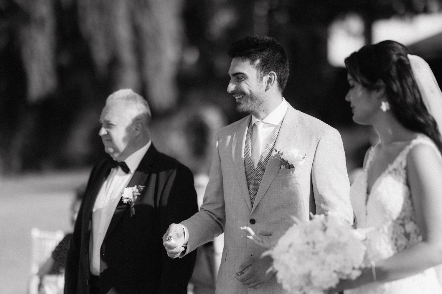 A black and white montage of wedding moments showing various people laughing and celebrating together at an elegant reception.