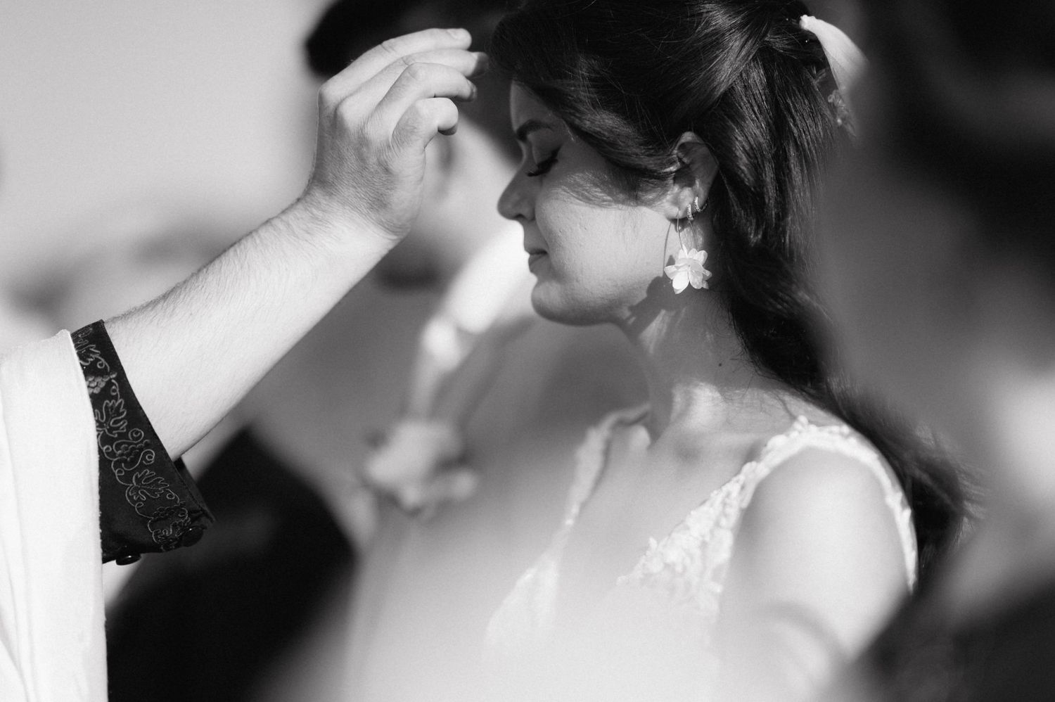 A tender black and white moment between newlyweds during their first kiss at the wedding ceremony.