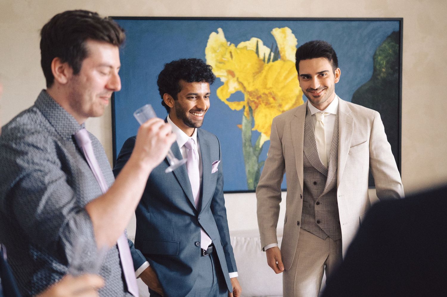 A group socializing at an event with a vibrant yellow flower decoration in the background.