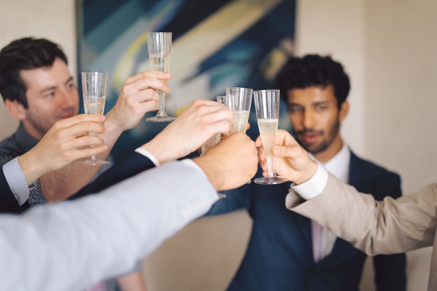 Friends raising glasses in a celebratory toast at a social gathering.