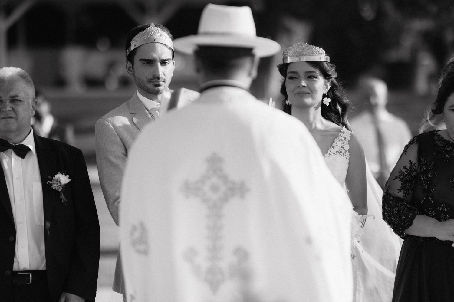 A group of individuals in white robes and formal attire gathered at an outdoor ceremony.