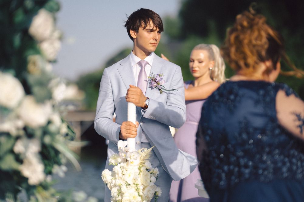Newlyweds dance together at an elegant outdoor wedding reception surrounded by floral arrangements.