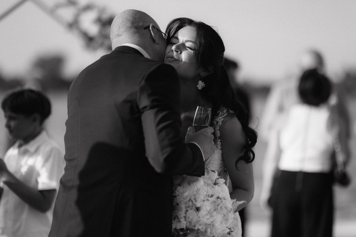 A black and white dance scene shows a tender moment between two dancers during a graceful performance.