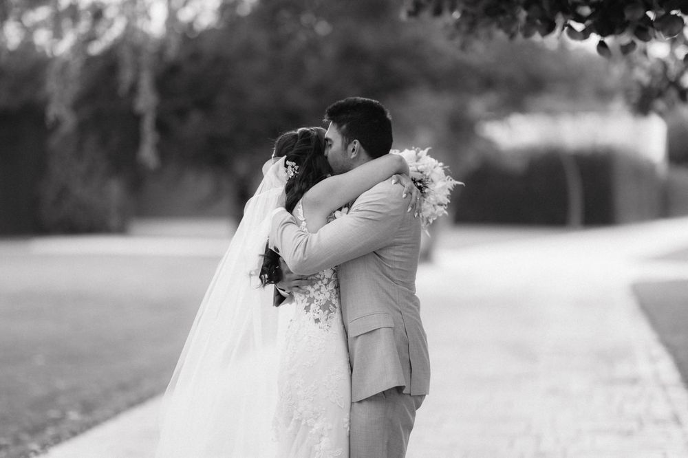 A romantic black and white wedding photo series showing couples sharing tender moments along a garden path.