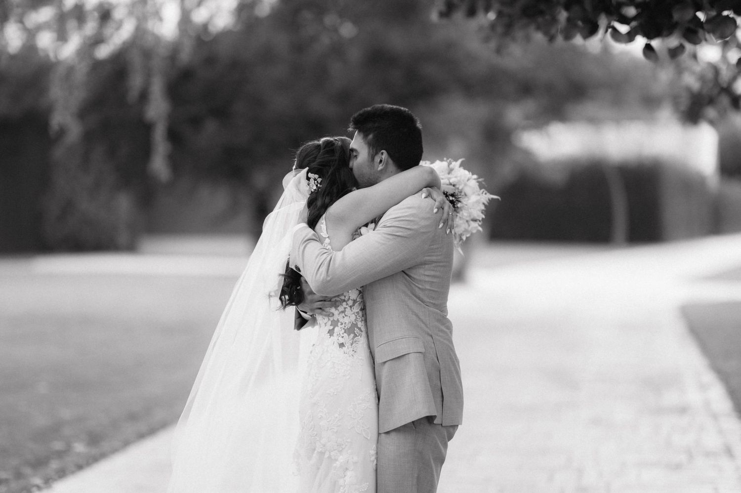 A romantic black and white wedding photo series showing couples sharing tender moments along a garden path.