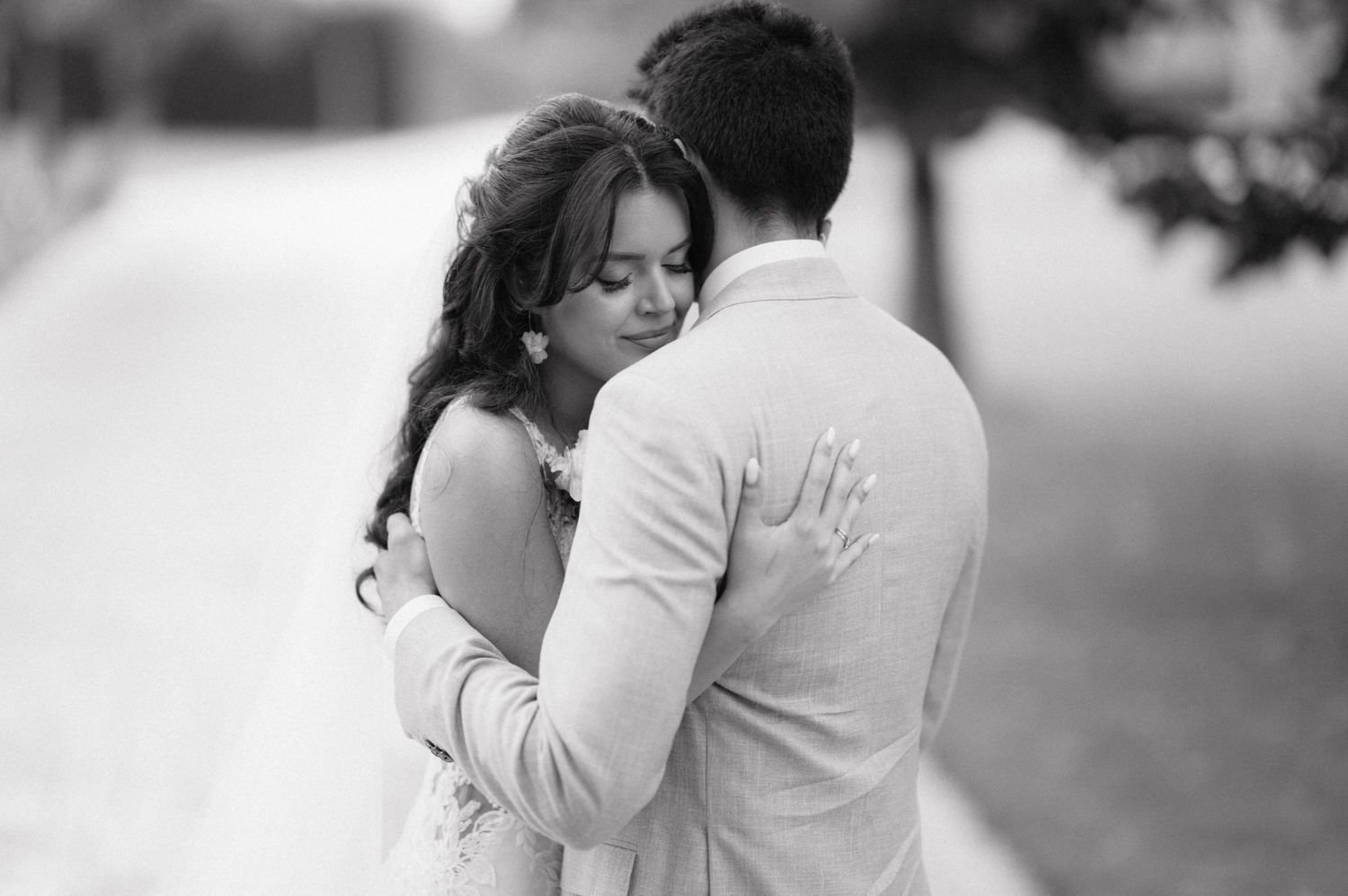 Black and white wedding photos showing tender romantic moments between couple embracing outdoors.