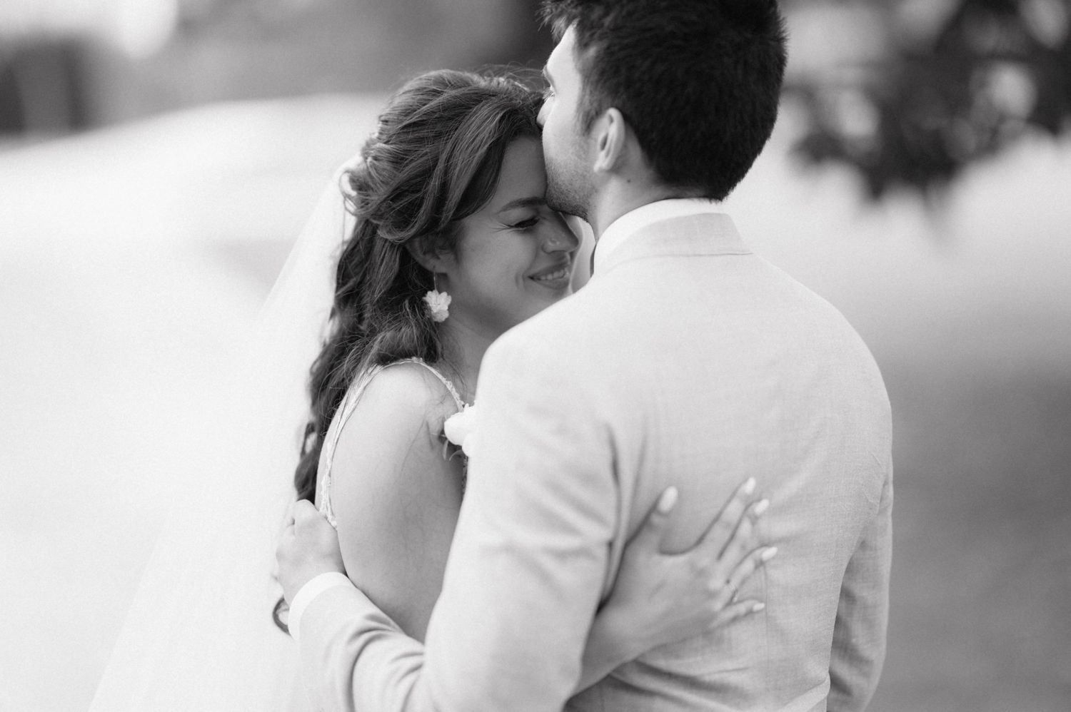 A series of tender black and white photographs shows a couple sharing intimate kissing moments outdoors.