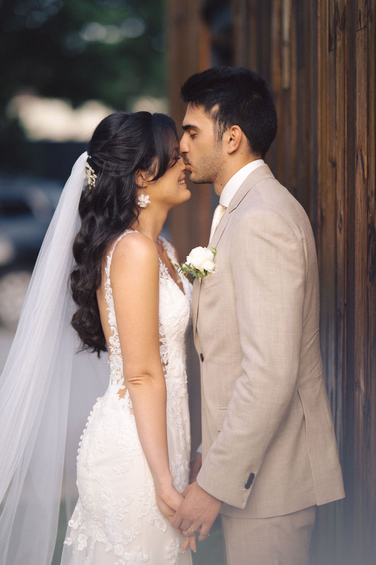 A bride and groom share intimate wedding day kisses in a series of romantic poses wearing beige and white formal attire.
