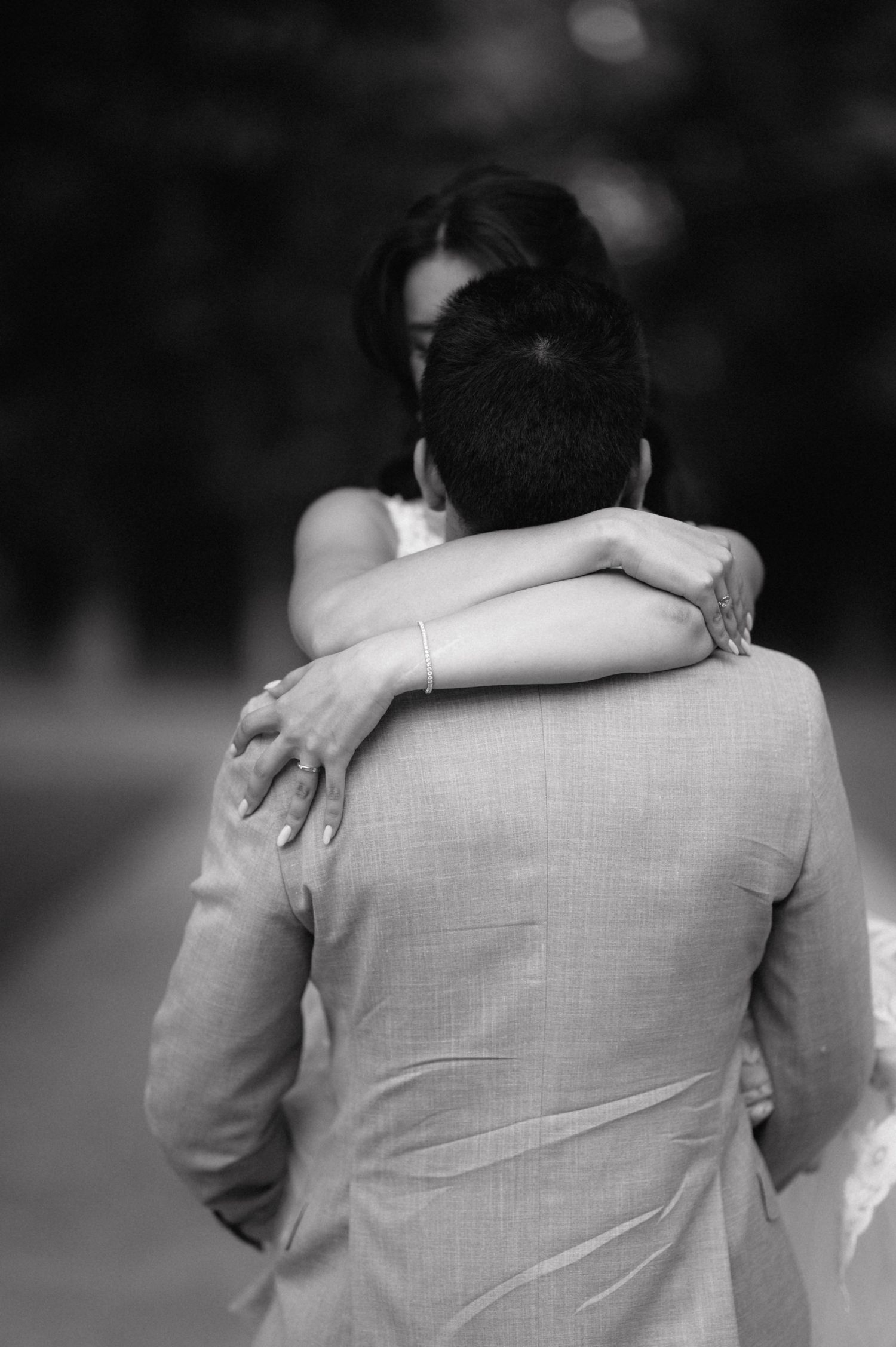 A series of black and white photos showing two people embracing in matching light colored outfits.