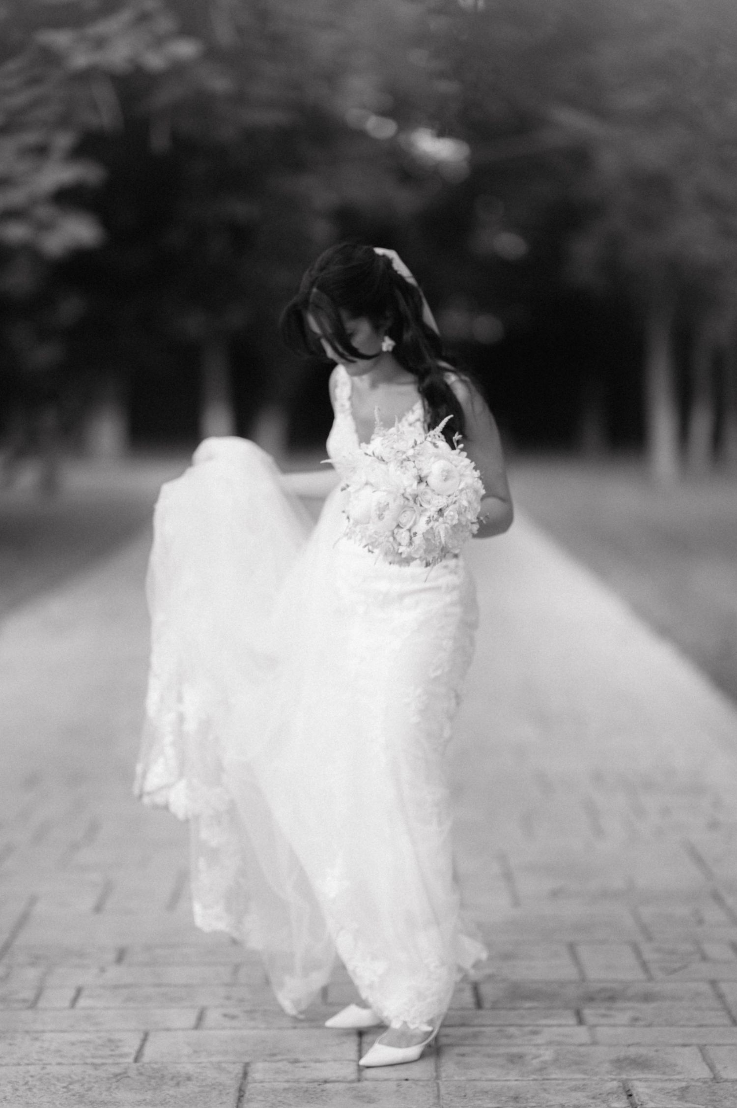 A bride in a flowing white wedding dress walks gracefully across a stone path in a black and white artistic photo sequence.