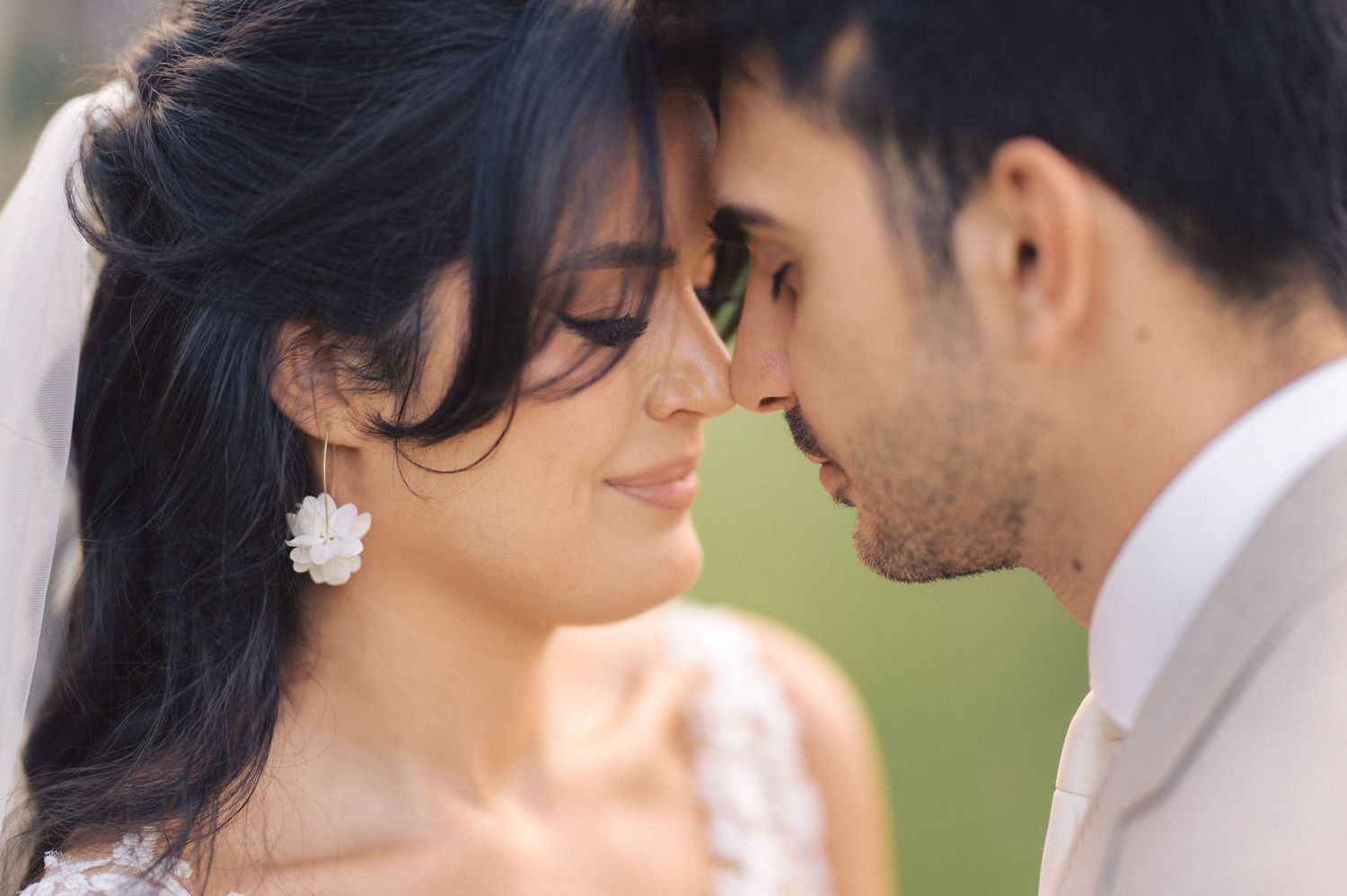 A romantic wedding moment captured in soft focus as a couple shares an intimate moment outdoors.