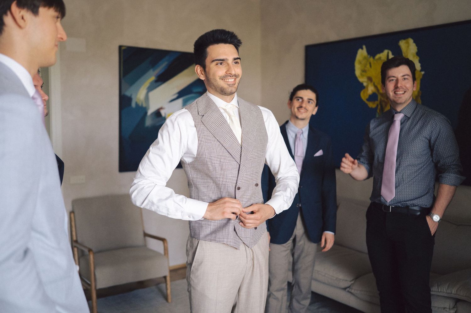 A group of people in business attire having a conversation in an office meeting or networking space.