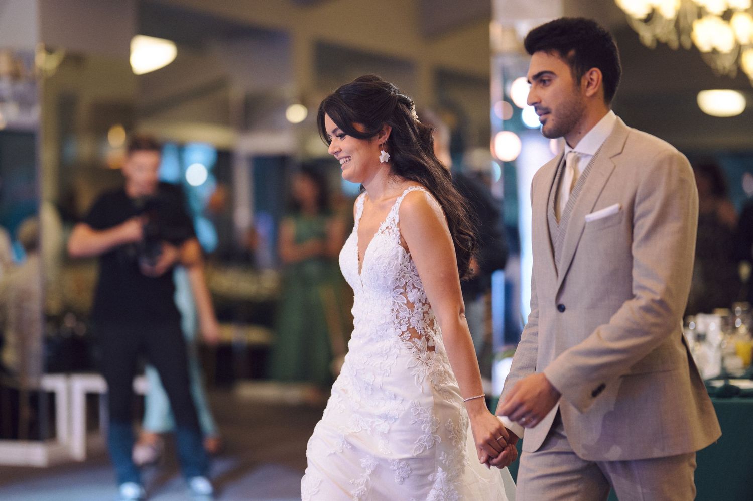 Bride and groom share an intimate dance together during their wedding reception in a warmly lit venue.