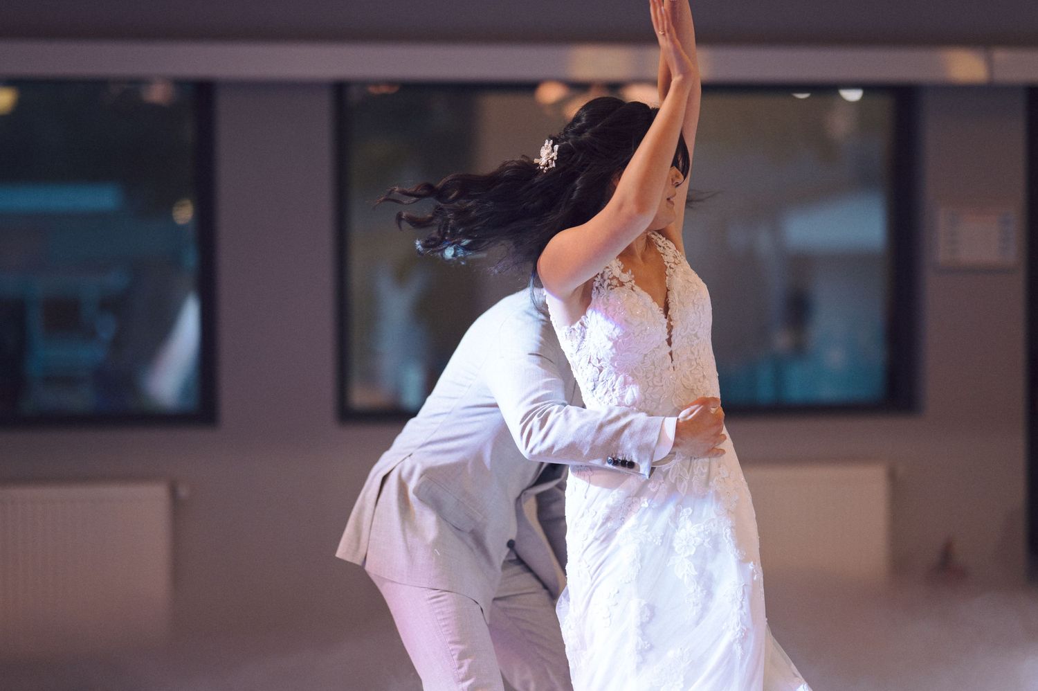 Ballet dancers in white tutus perform graceful movements during a classical dance rehearsal on stage.