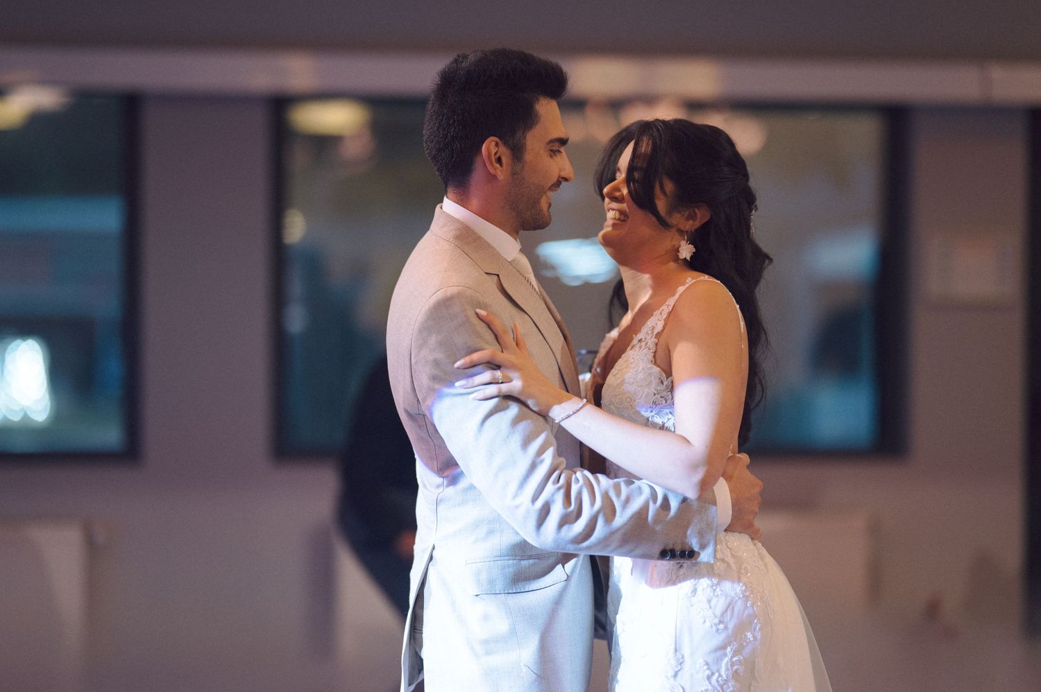 A couple shares their first dance together at their wedding reception in an elegant indoor venue.
