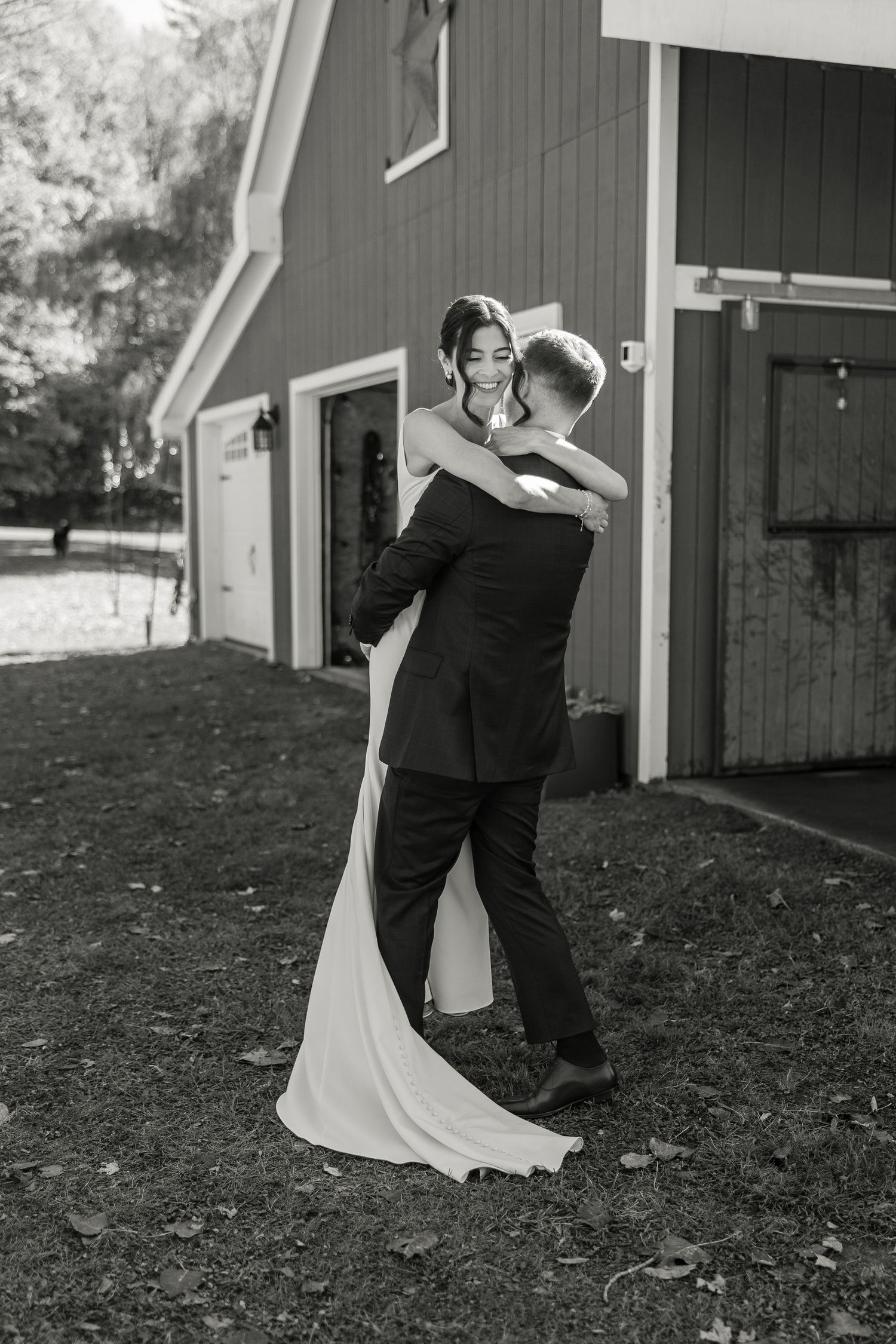 Olivia and Cory's sharing a big hug at their backyard wedding Vermont, in black and white.
