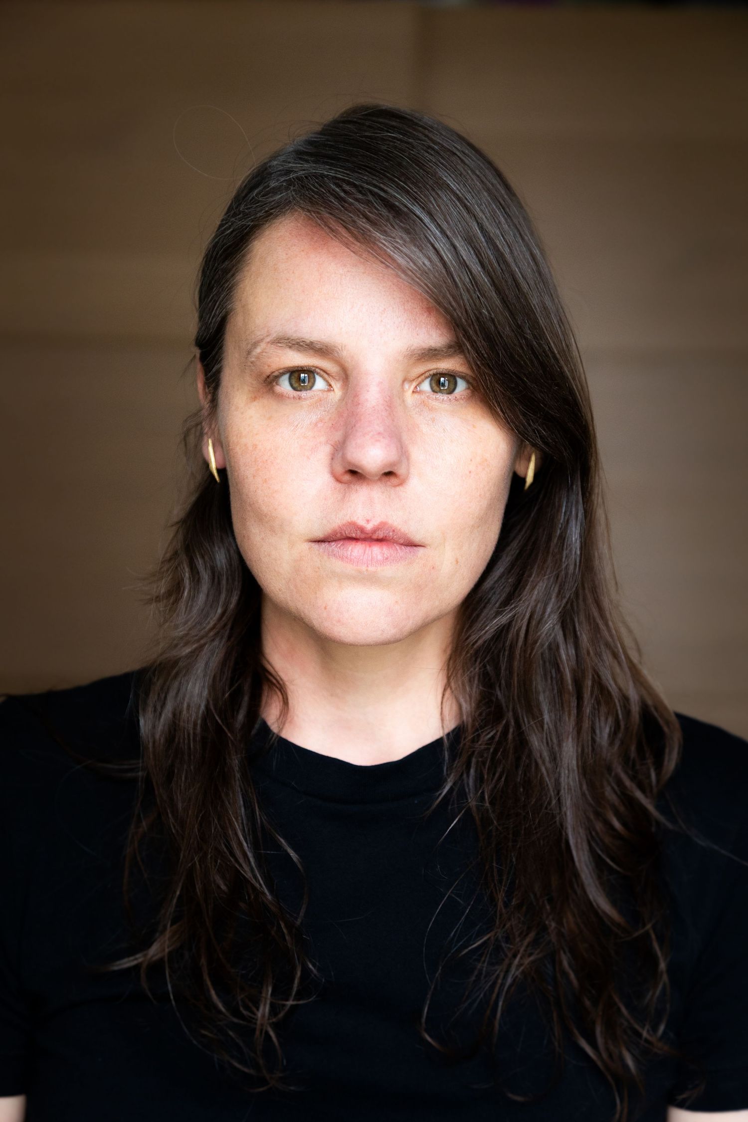 Dramatic portrait series showing different angles and shadows of dark-haired person in black turtleneck against neutral background.