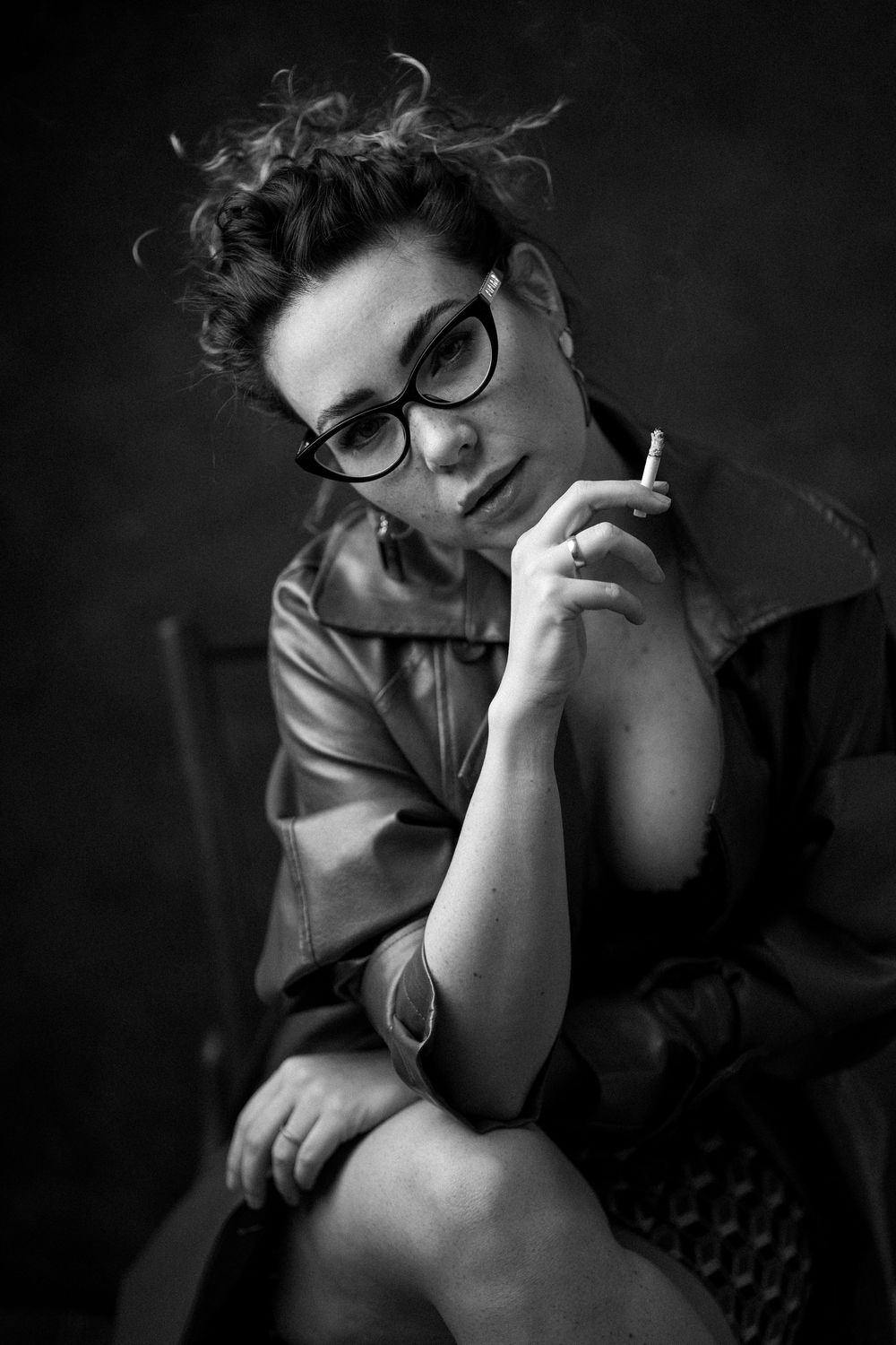 A monochromatic sequence of photos shows a figure in glasses smoking a cigarette in dramatic lighting.