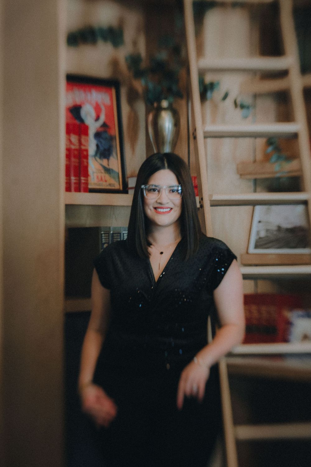 A person wearing a black outfit sits in a blurred vintage-style collage of five similar poses against a warm background.