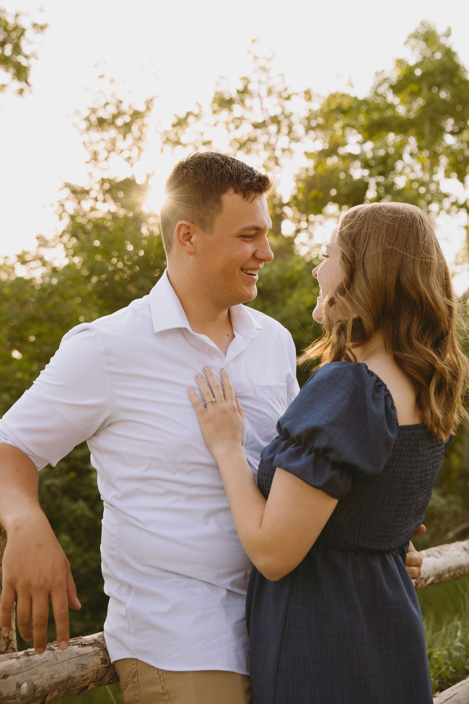 A couple shares an intimate moment at the edge of a scenic canyon with red rock formations stretching to the horizon.