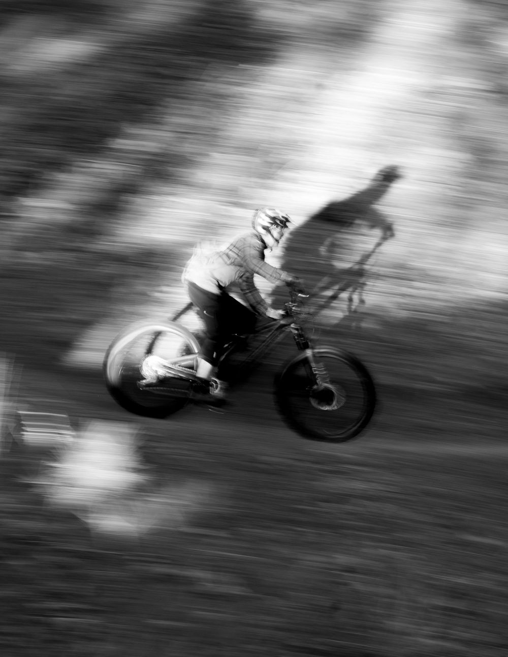 Mountain biker in motion captured in dramatic black and white blur effect.