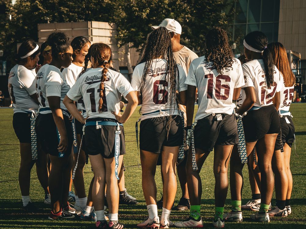 Team members gather on the field wearing matching uniforms during practice.
