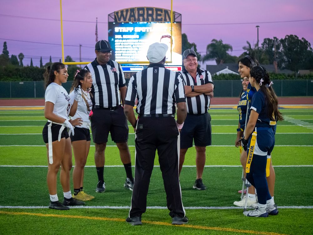 Officials and players meet on field under stadium lights at Warren High School.