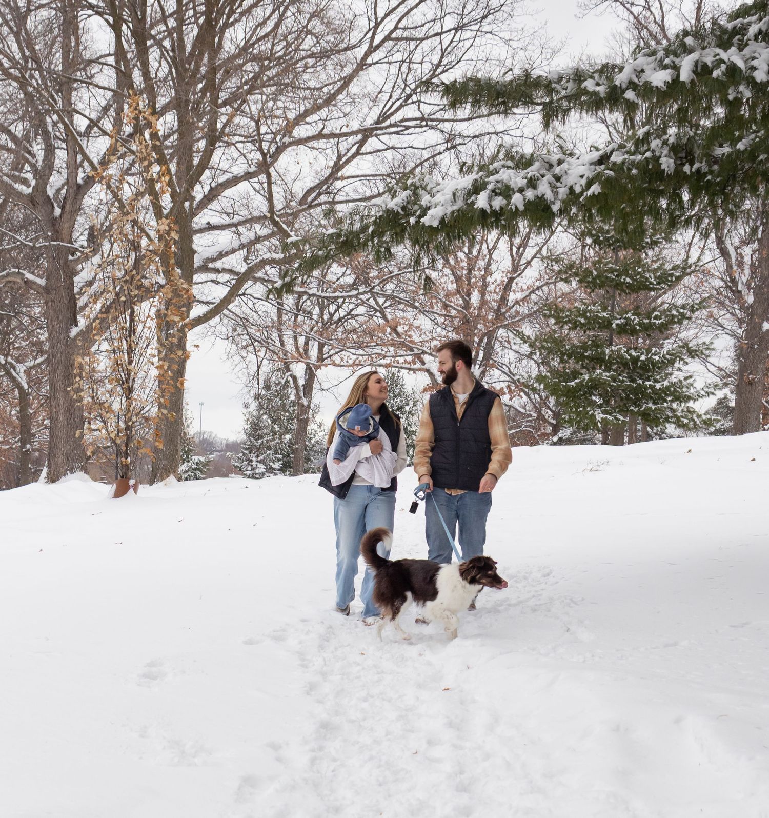 Family taking a stroll together on a sunny path through green woods.
