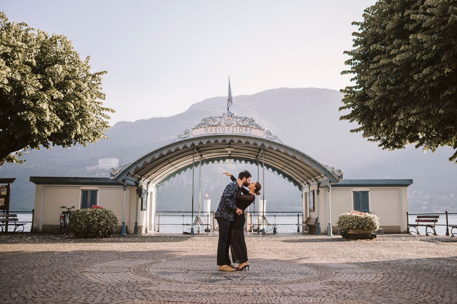 Coppia di innamorati si scambia un bacio nella piazza dell'imbarcadero di Mandello del Lario.
