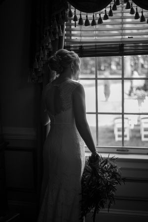 Bride looking out at ceremony through window