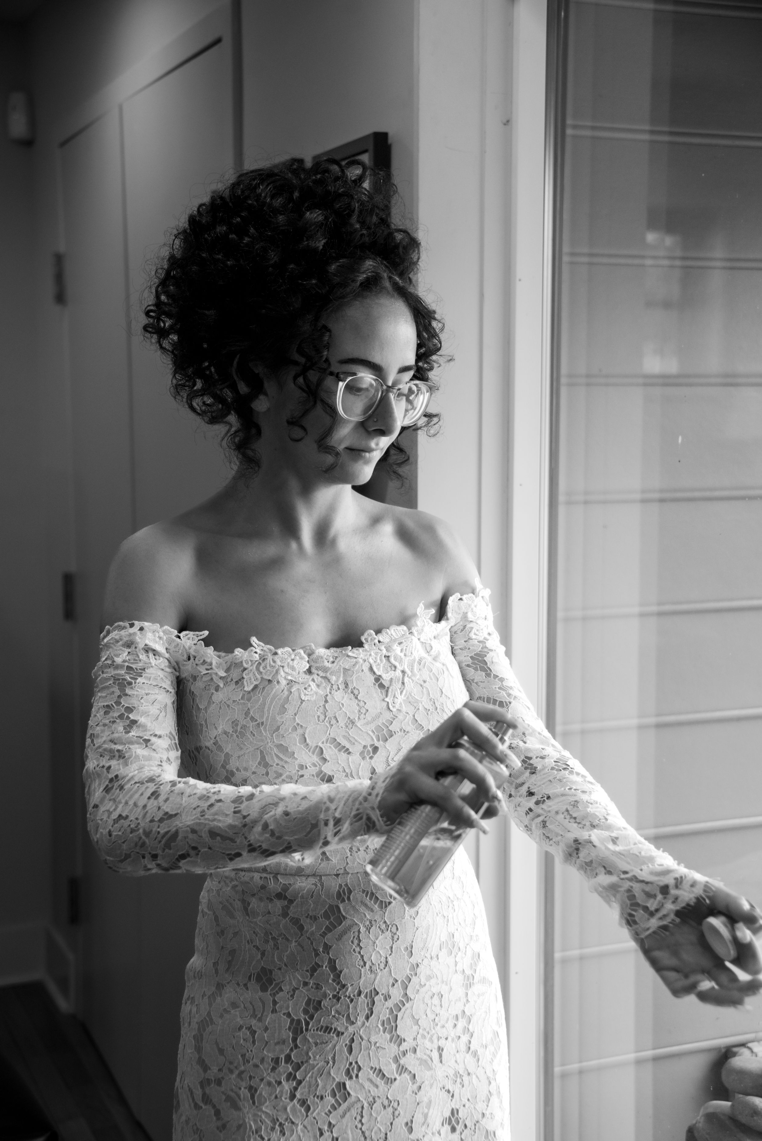 Bride spraying perfume on wedding day
