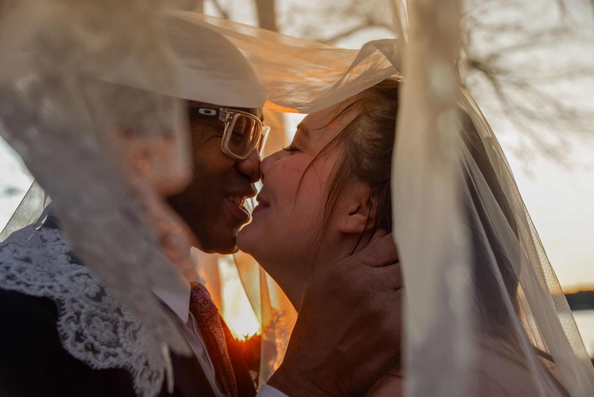 Bride and groom, kissing with sunset