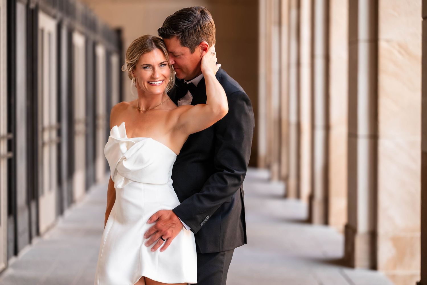 Romantic couple lying on lush green grass while embracing each other at their outdoor Grand Rapids wedding